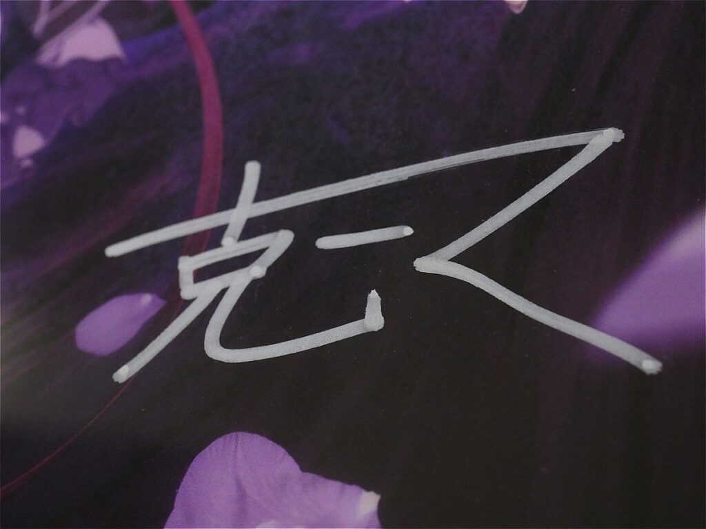 White autograph-style signature on a dark purple floral background