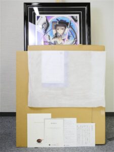 Cardboard shipping box with a framed anime illustration on top, wrapped in white tissue, and papers arranged at the front.