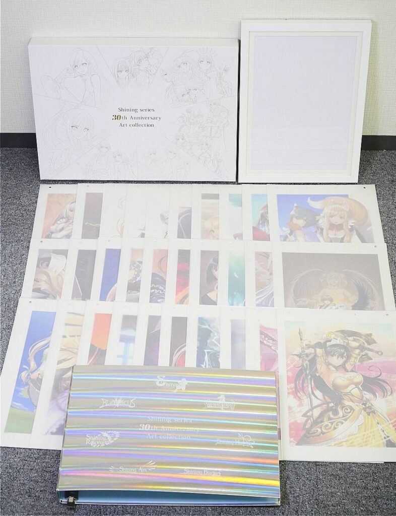 White Shining series 30th Anniversary art collection box with sheets of anime illustrations spread on the floor