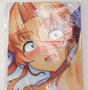 Close-up of an anime-style illustration: a smiling, orange-haired girl with wide eyes, wrapped in plastic as a packaged poster or blanket.